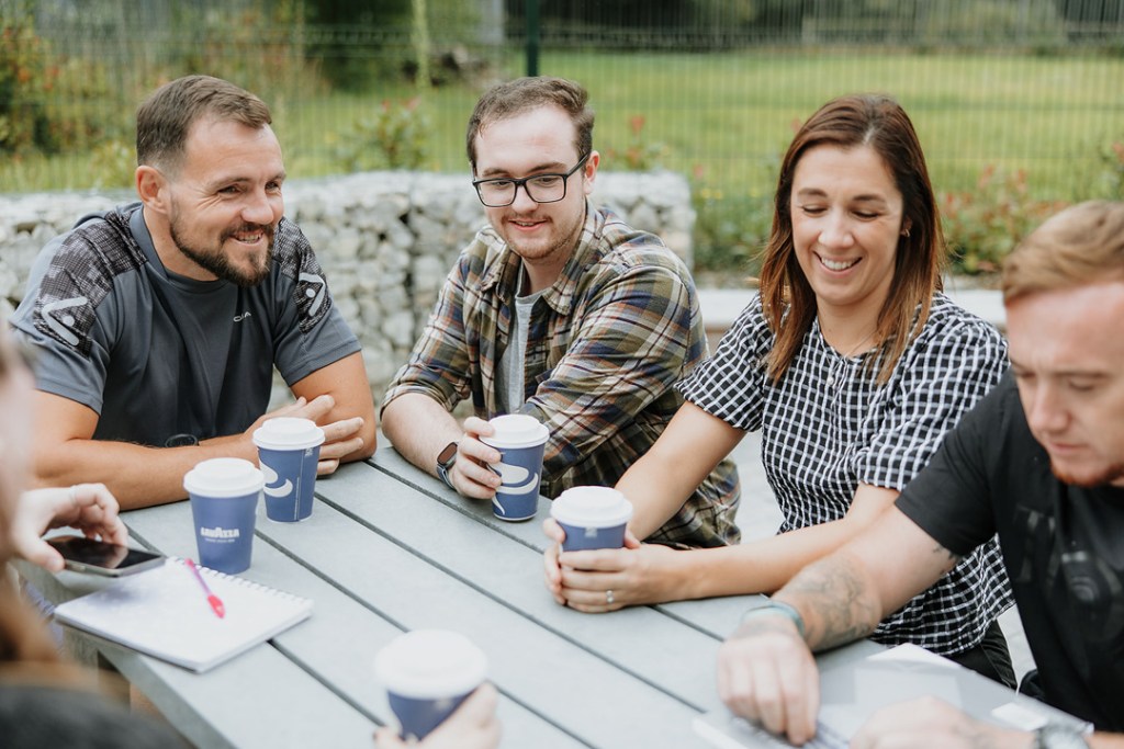 Group of Lifeworks participants smiling and drinking coffee